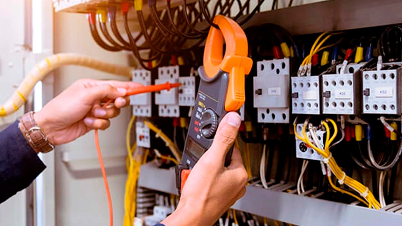 Técnico realizando medição em painel elétrico industrial