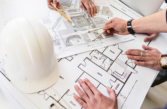 Profissionais analisando planta de engenharia civil